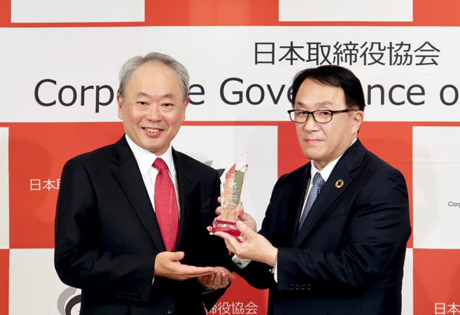 表彰式にて：冨山和彦日本取締役協会会長（左）と此本臣吾NRI代表取締役会長 兼 社長（右）